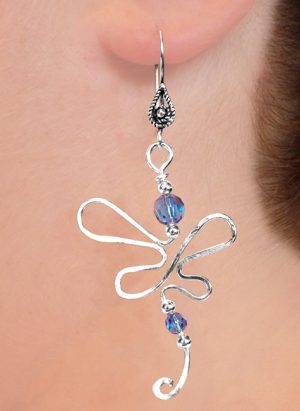 Single earring hanging from models ear designed in the shape of a Dragonfly with two blue beads. | Ear Curls, Ear Climbers