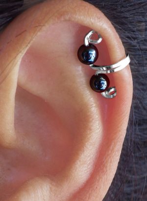 A mini ear cuff is shown on a models ear that is silver with black beads. | Ear Curls, Ear Climbers