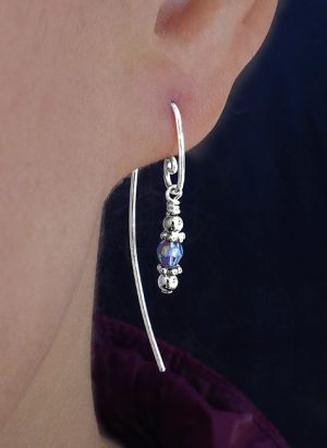 Single drop earring hanging from models ear with a blue bead. | Ear Curls, Ear Climbers
